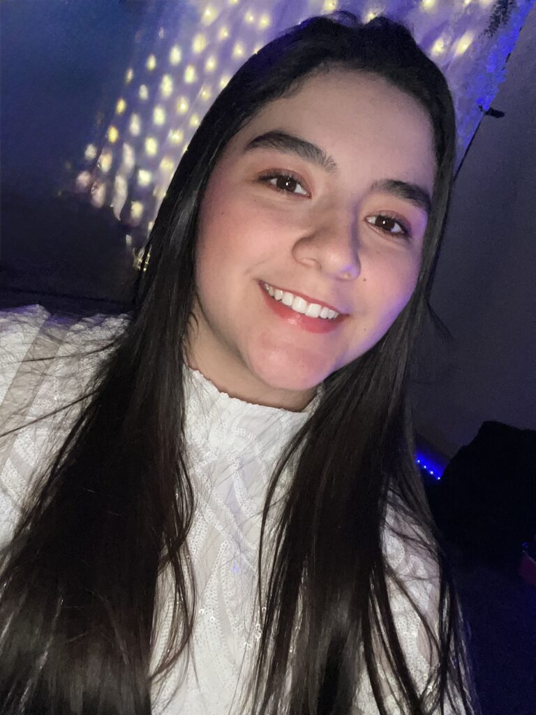 Portrait of Community Connector, Camila Gutierrez on dark background.