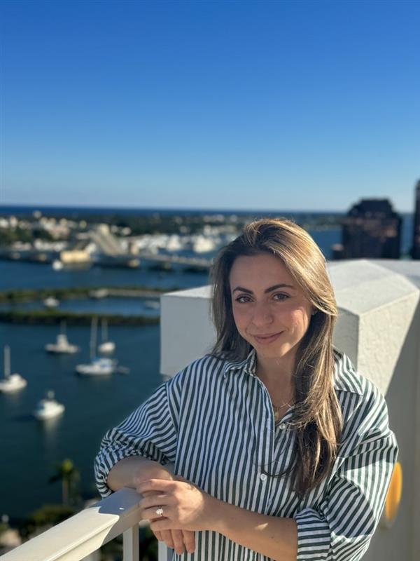 Community Connector, Rachel Bohbot is in the forefront, with a marina in the background.